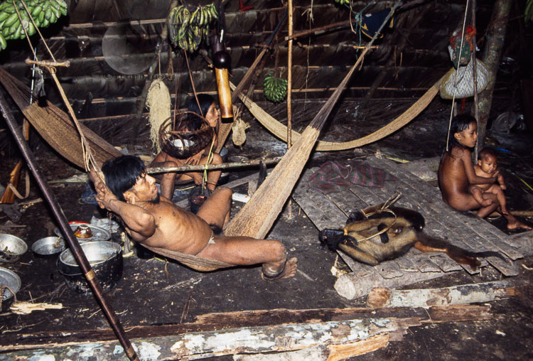 Waorani Indians,  The nuclear family clusters around their fire in the longhouse, Gabado, Ecuador, 1973